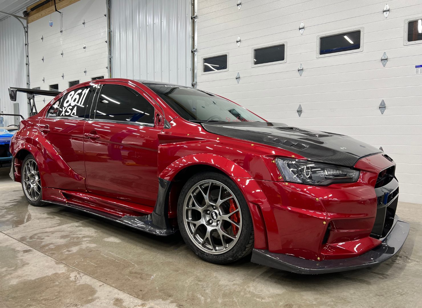 Cora's red Varis widebody Mitsubishi Evo X at Grade A Garage