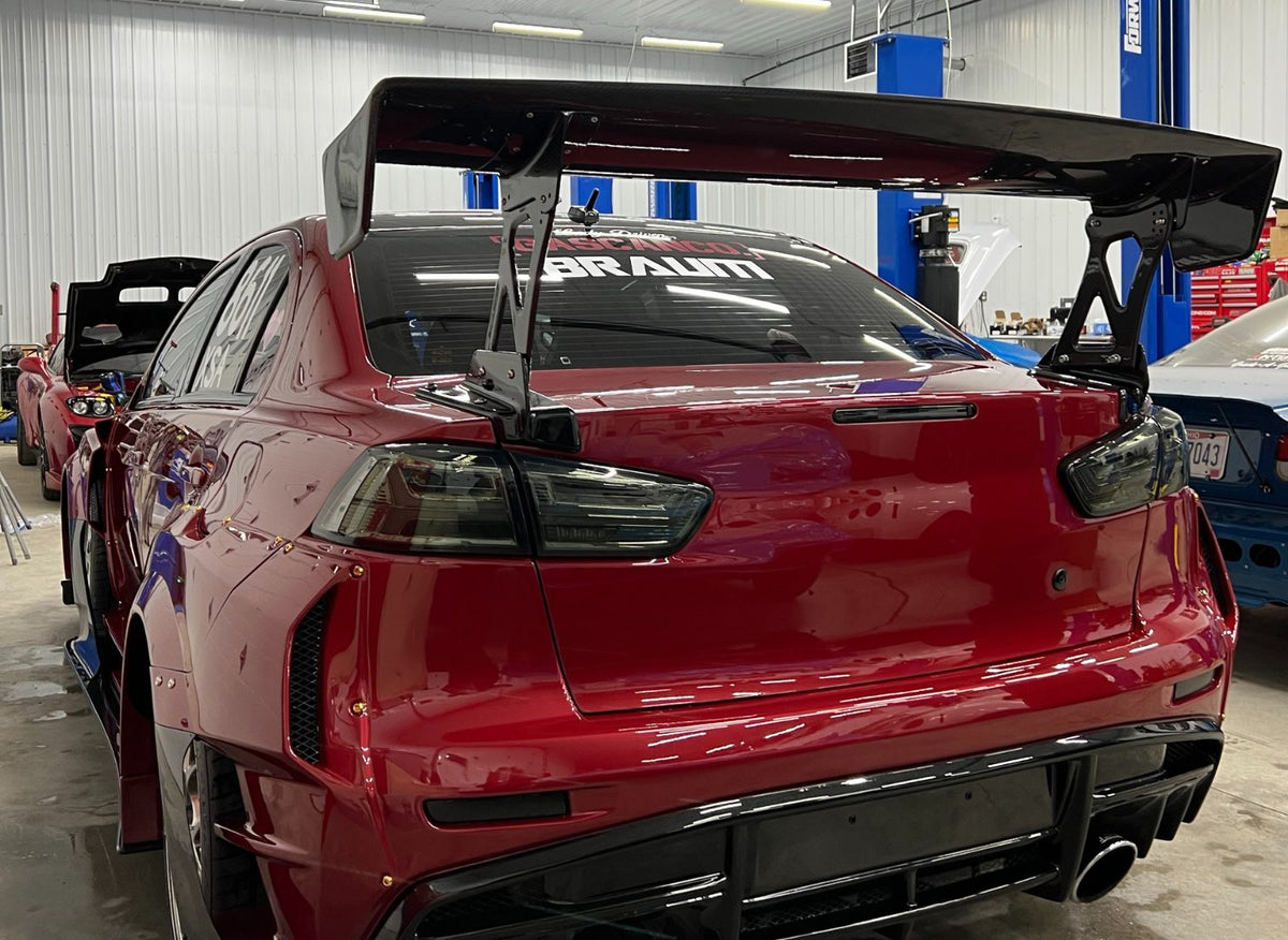 Rear view of Cora's widebody Evo X with a large wing