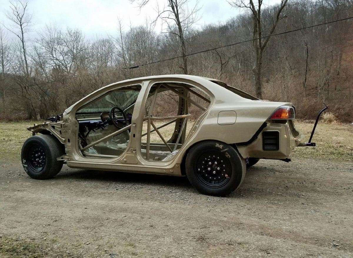 Stripped Mitsubishi Evo X shell with a welded roll cage