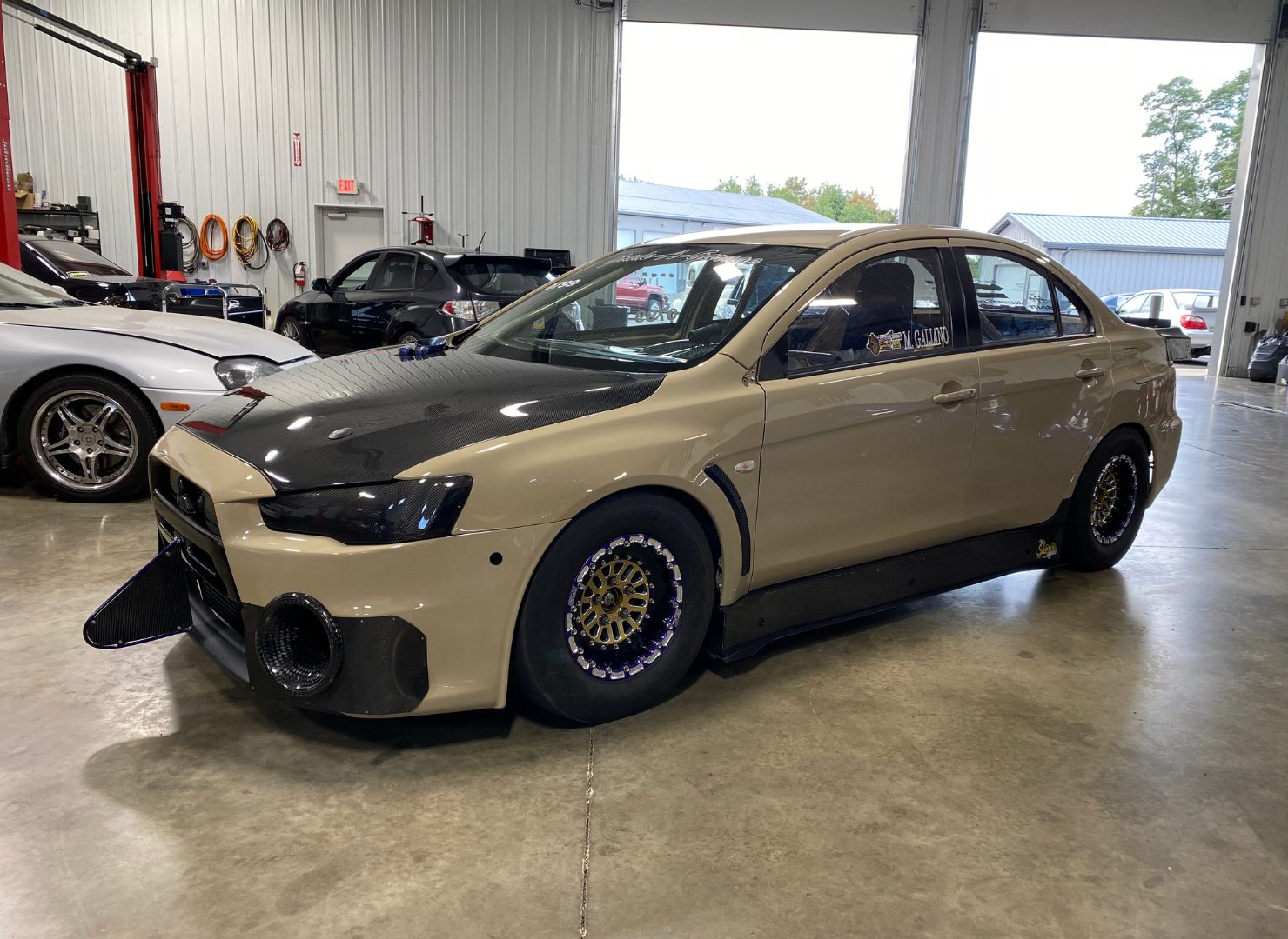 Beige Mitsubishi Evo X drag car in the Grade A Garage shop